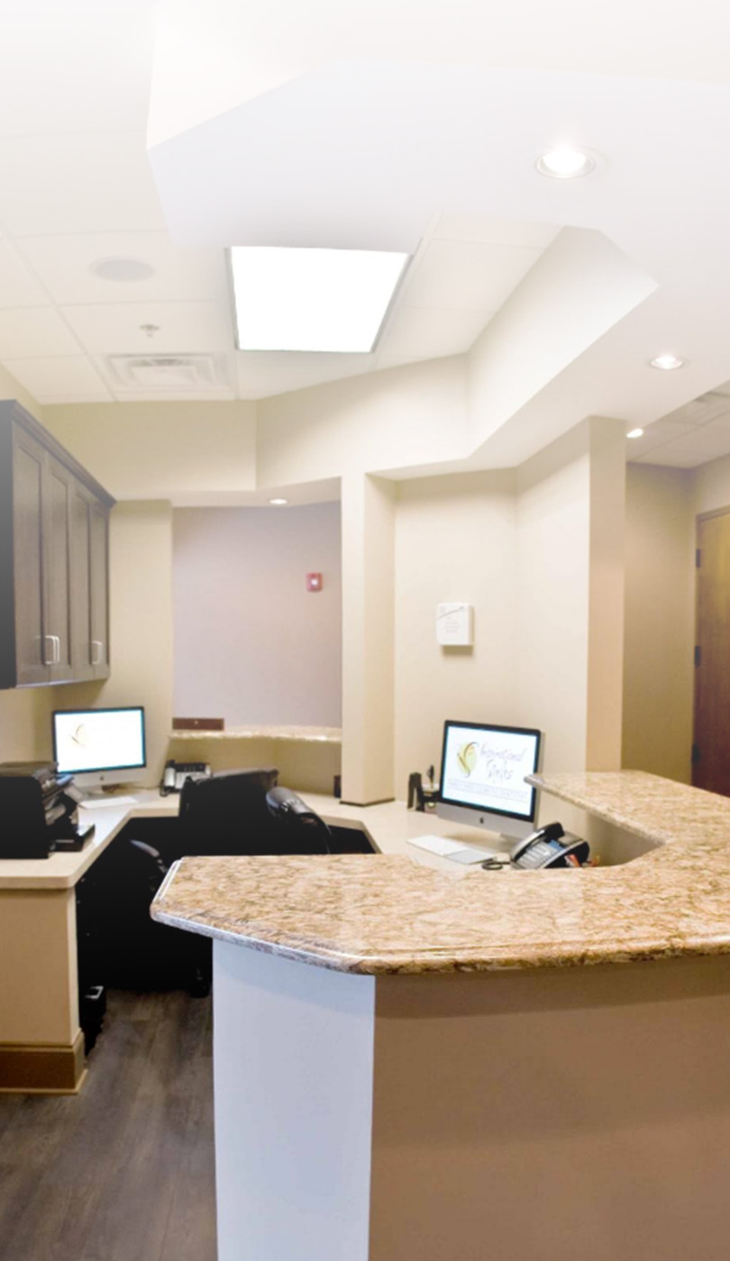 The image shows a modern dental or medical office interior with a dental chair, equipment, and a clean, professional environment.