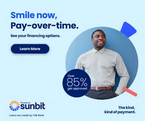 The image features a man standing against a blue background with a smiling expression, wearing a shirt and tie. He is positioned in front of a graphic design element consisting of a circular arrow pointing downwards towards a percentage sign indicating 85 . To his left, there s text that reads  SMILE NOW, PAY-OVER-TIME,  suggesting an advertisement for flexible payment options. Below this headline, there is additional text stating  SEE YOUR FINANCING OPTIONS  and a button labeled  Learn more.  The image also includes the logo of Sunbit at the top right corner.